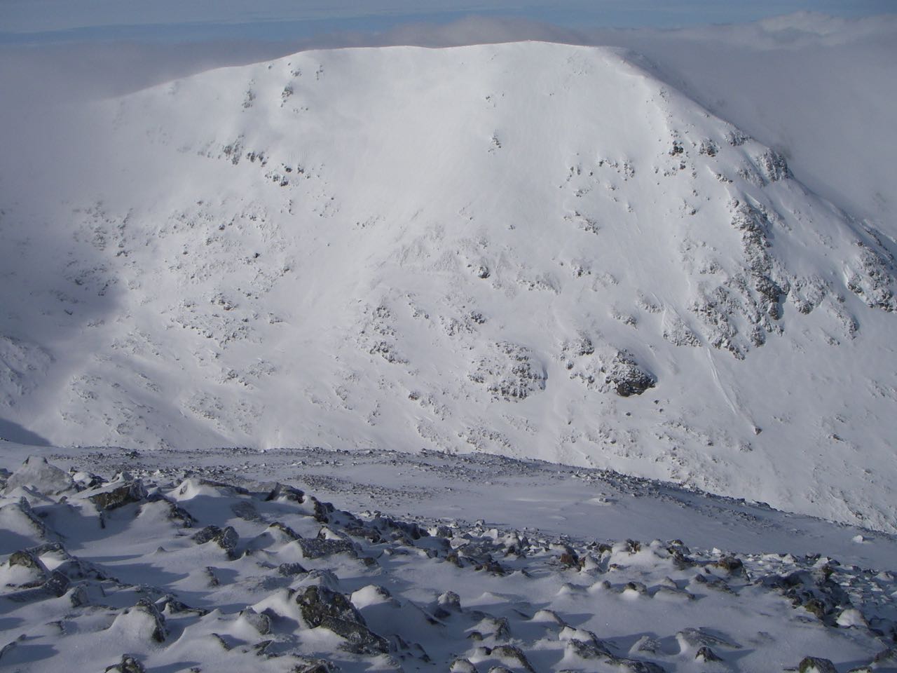 Looking West from Meall a Bhuiridh contrasting its scoured West flank (near ground) with the loaded East face of Creise